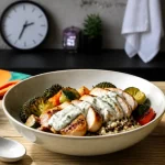 Bowl poulet-quinoa riche en protéine repas, légumes rôtis et sauce yaourt-citron